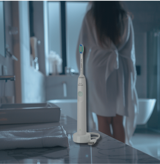 a woman in a robe is standing in front of a sink
