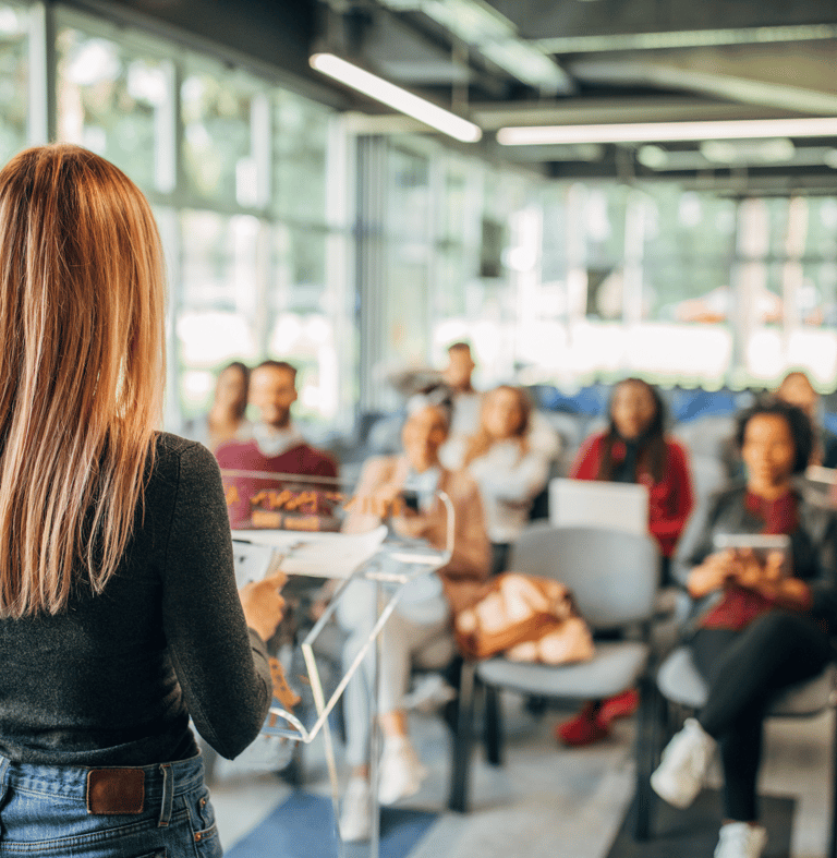 A woman practicing her presentation and persuasion skills in front of an audience.