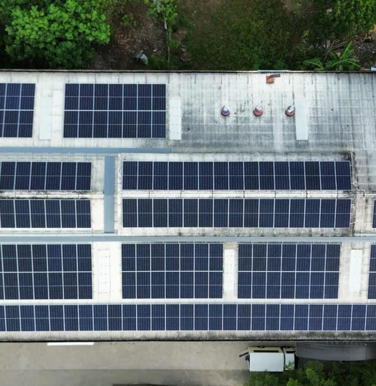 Aerial view of a commercial building rooftop with a large solar panel installation for renewable energy.