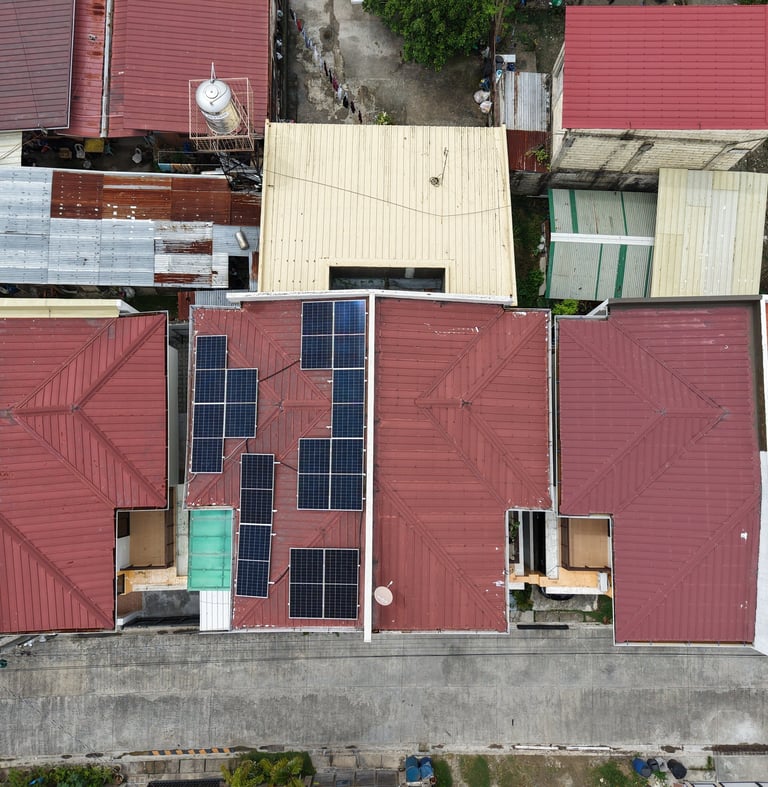 Aerial view of residential rooftops with installed solar panels for sustainable home energy.