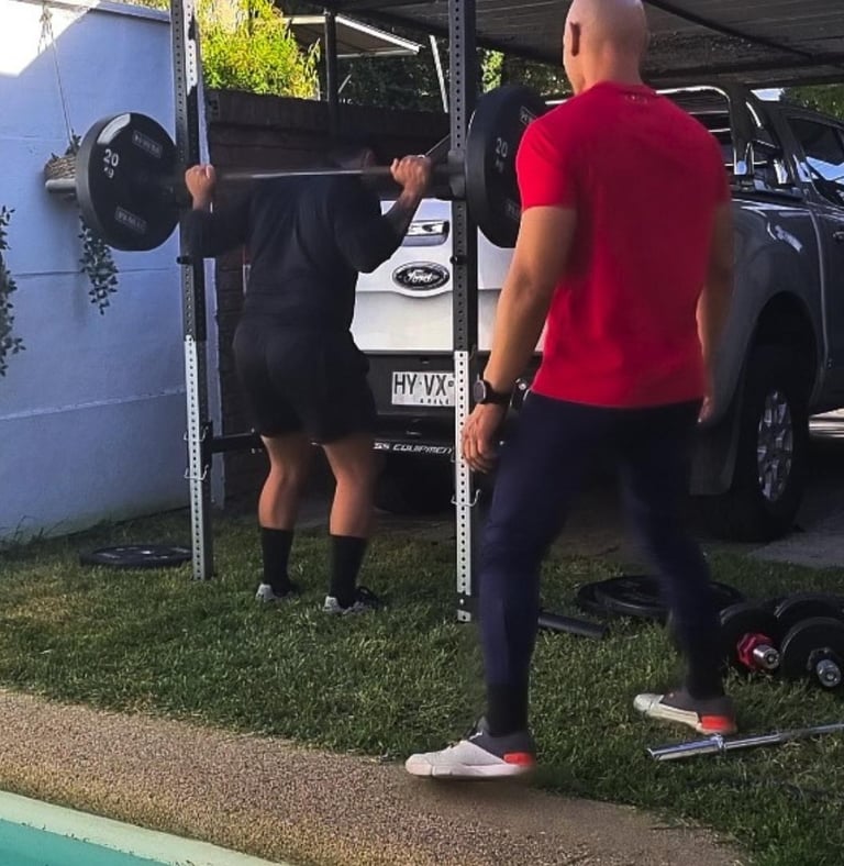 Cliente preparándose para sentadillas. Servicio de personal trainer en Vitacura.