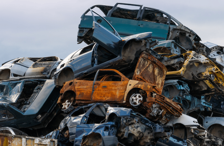 A heap of junked cars sitting on top of each other.