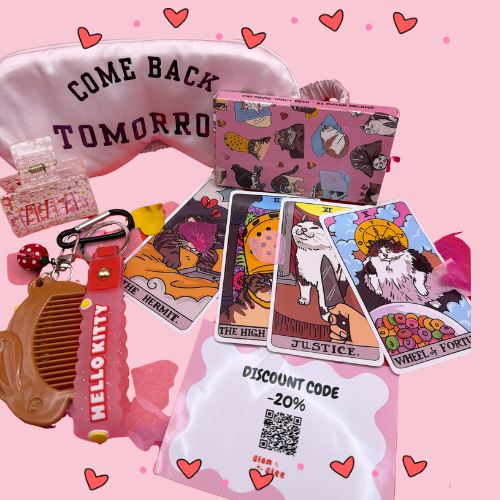 A pink collection of cat tarot cards, silk eye mask, and Hello Kitty accessories on a pink background.