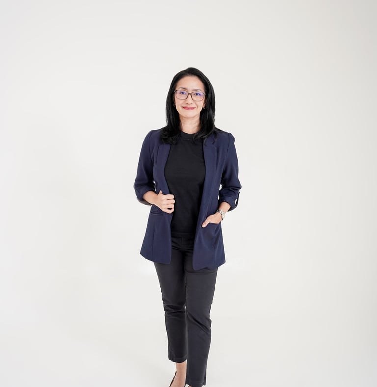 Professional woman in a navy blazer and glasses posing for a business headshot portrait.