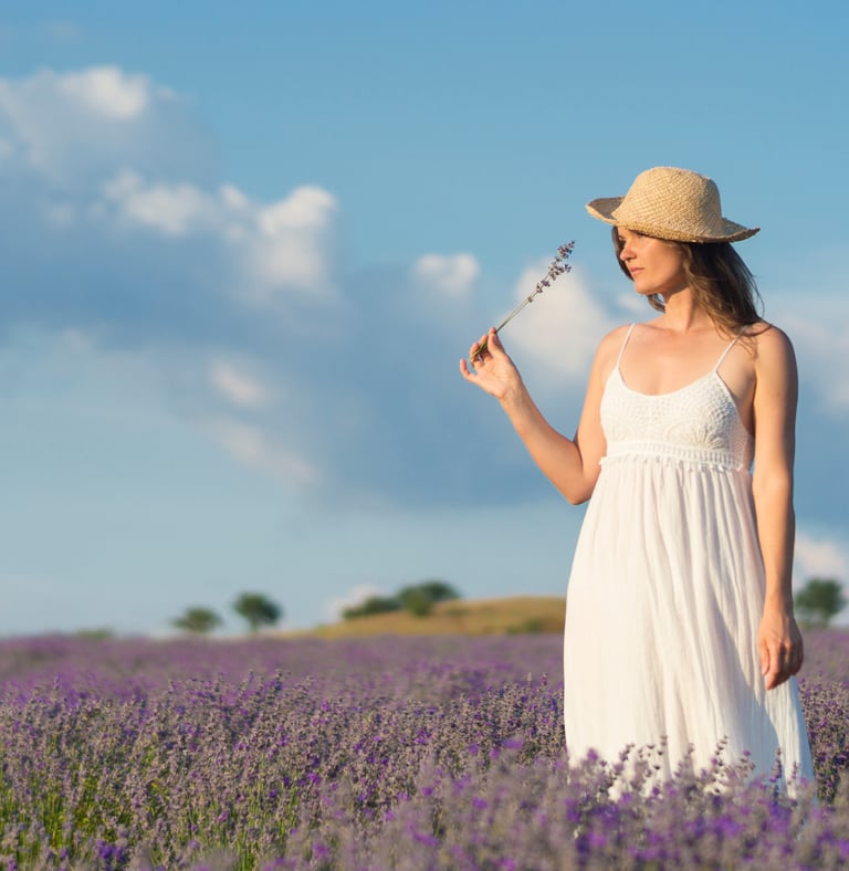 a woman in a white dress and straw hat holding a wand