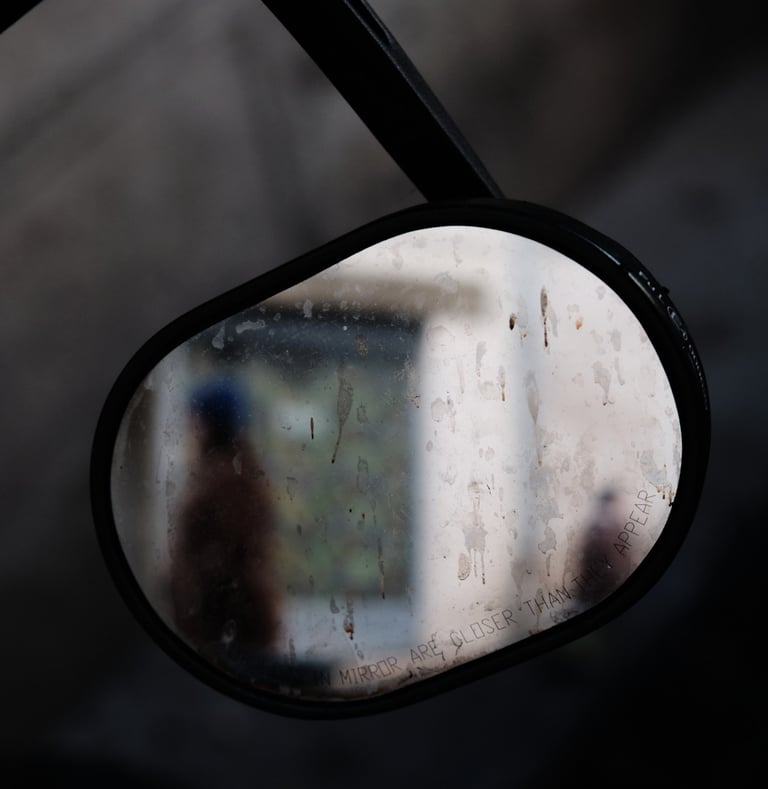 people reflections in a motorcycle mirror