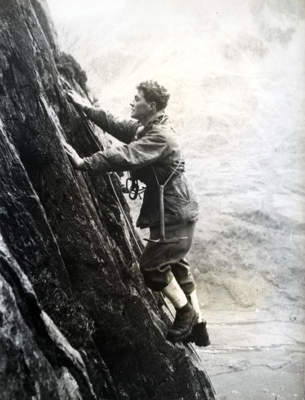 a pioneer of alpinism climbing a rock cliff