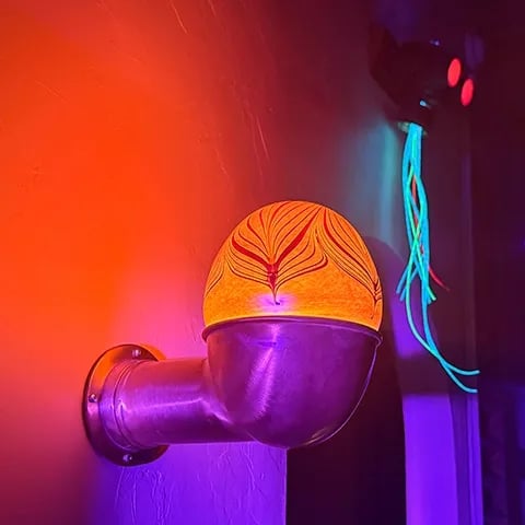 Sconce made from brass boat vent with custom blown glass cover.