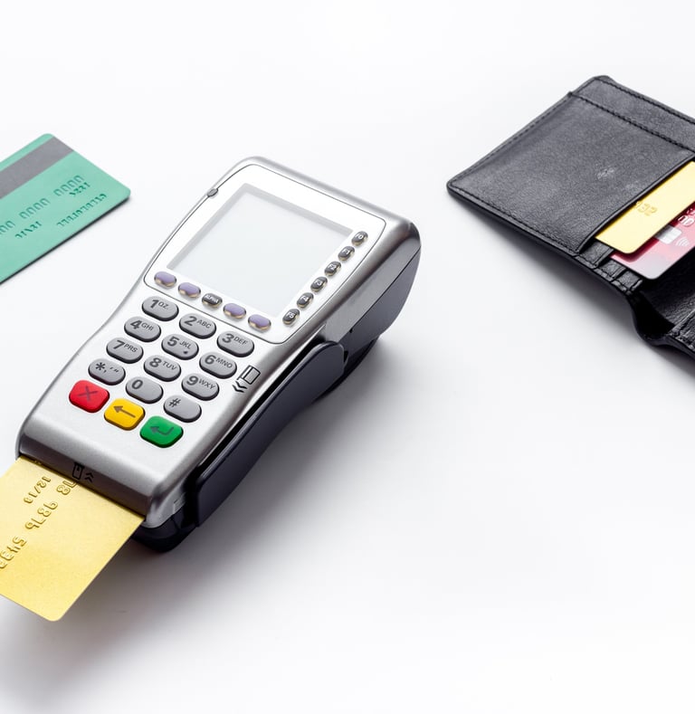Terminal de paiement par carte bleue posé à côté de deux cartes bleues