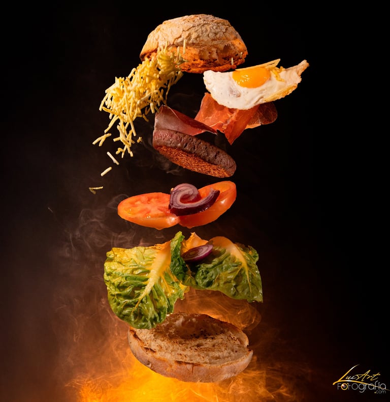 Fotografía gastronómica de hamburguesa con ingredientes flotando como pan, huevo, bacon, verduras y 