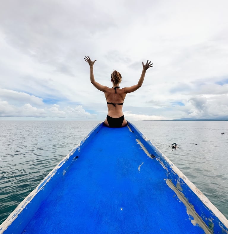 a man sitting on a boat in the ocean