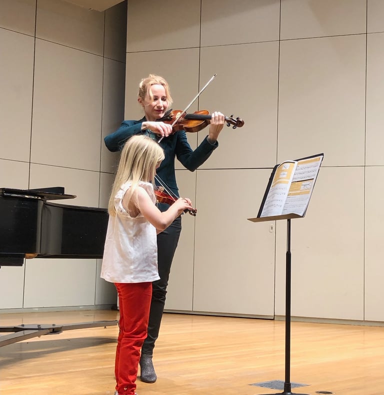 Houston violin teacher performing at a recital with her violin student