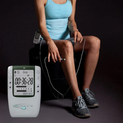 Young woman applying Alpha Stim M on her knee.