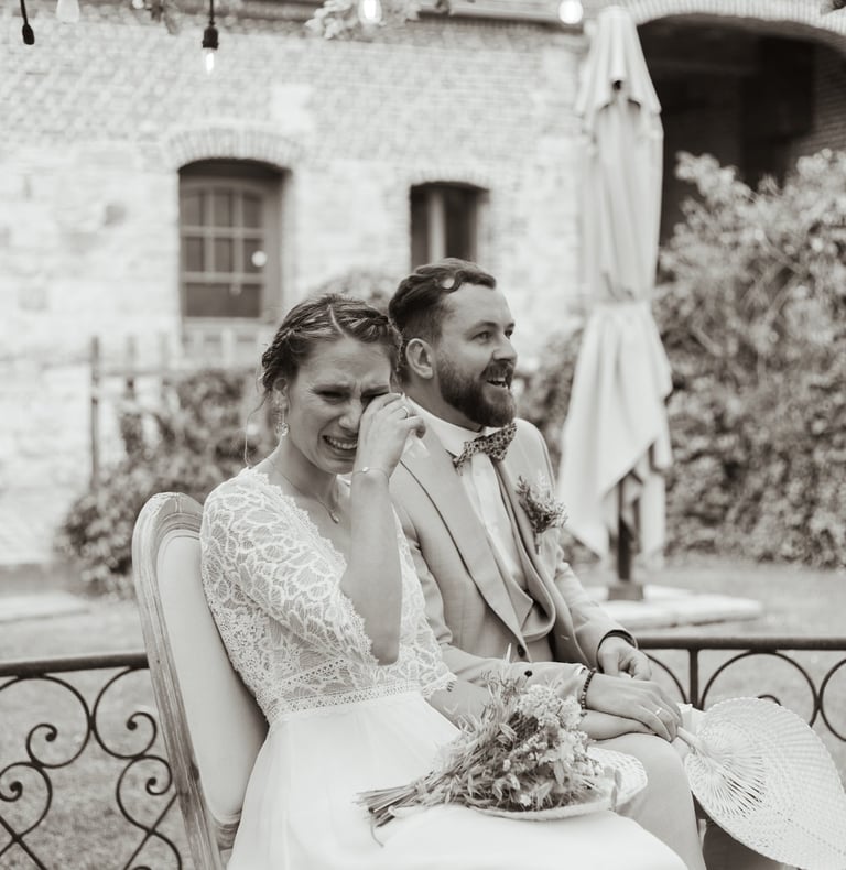 a man and woman sitting on a bench in a garden