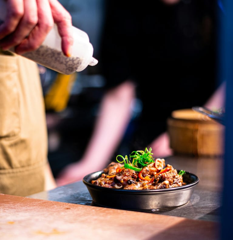 chef is pouring sauce over a delicious oven dish ready to be served