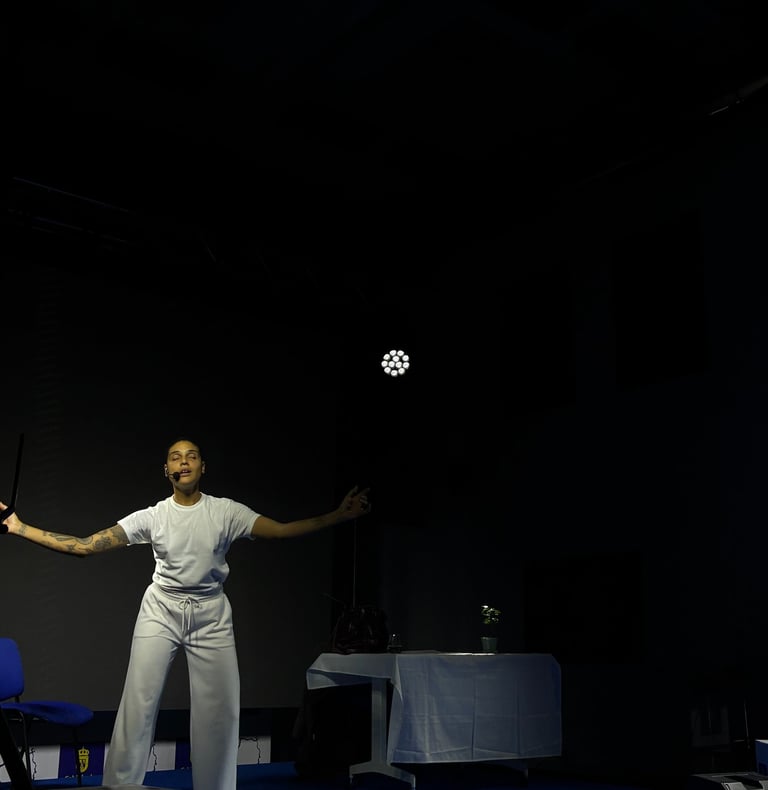 una mujer afrodescendiente vestida de blanco actuando en un escenario