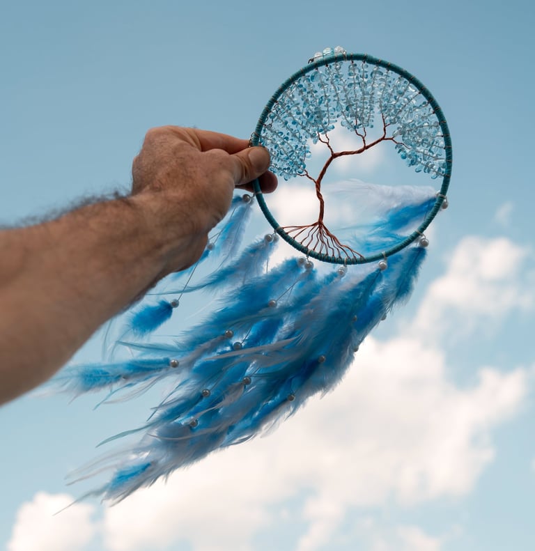 a person holding a blue feathered dream catcher