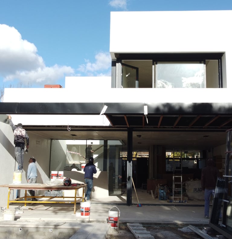 a man standing in front of a house with a large window