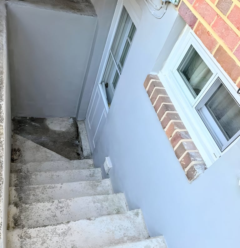 Before image of worn and uneven concrete exterior steps. 