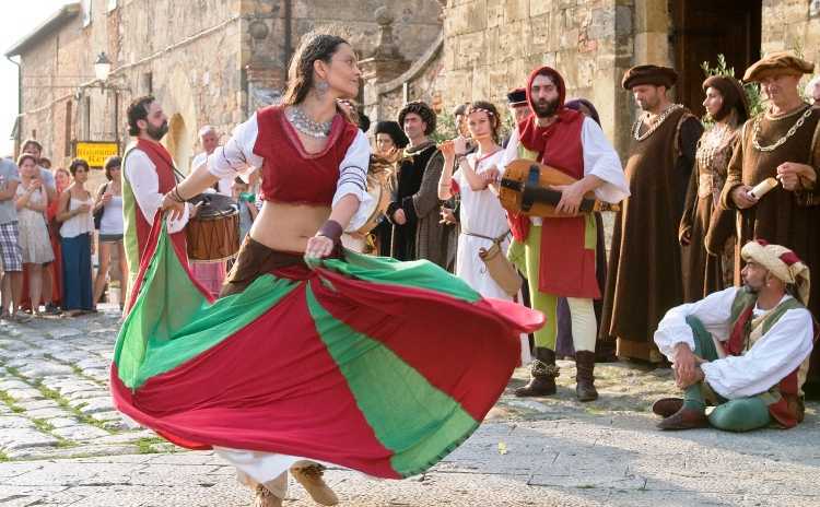 Medieval dancer at the Monteriggioni Medieval Festival with musicians and performers in period costu