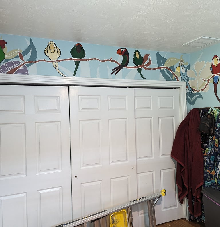 Painting a parrot mural on a large wall with a closet door.