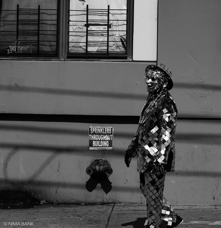 black and white shot of a brooklyn street performer in a metallic mirror costume