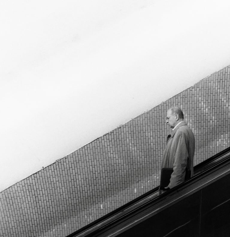 a man in a gray jacket is walking up an escalator in the parisian subway