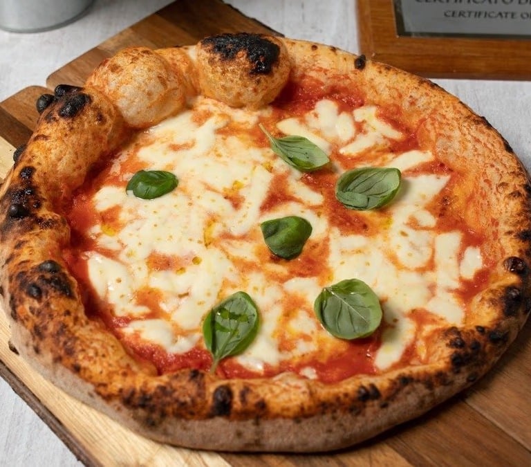 Pizza margarita napolitana servida en una pizzería del centro de Bratislava, con masa esponjosa, tom