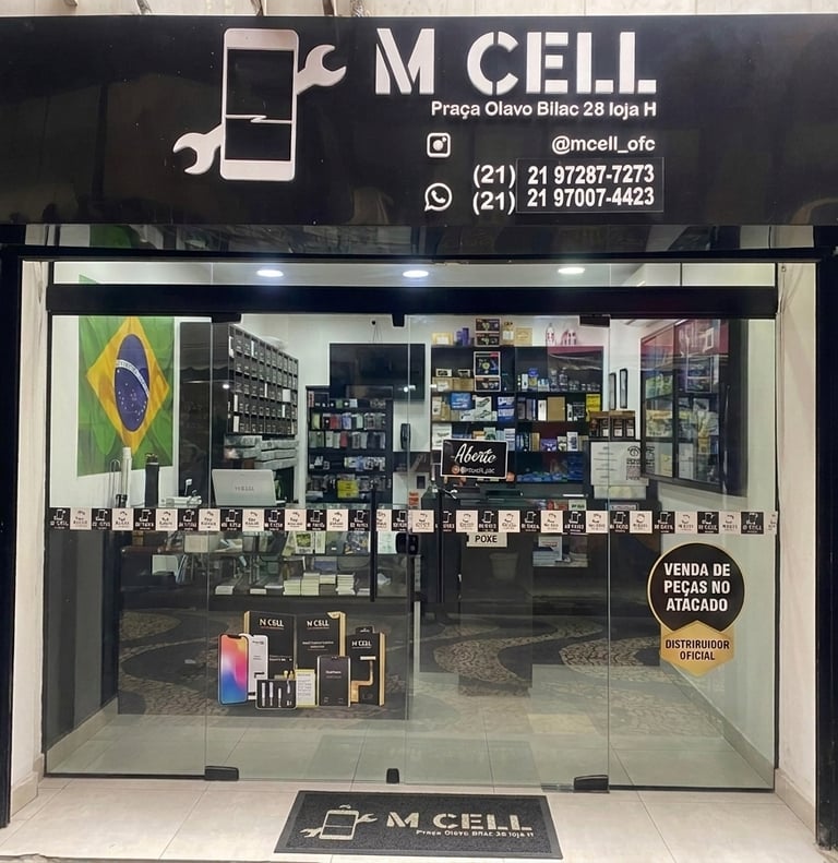 M Cell smartphone repair shop storefront with glass doors and mobile accessories on display.