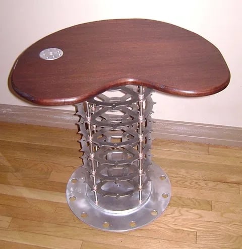 Coffee table with wood top and aluminum body made of gears.