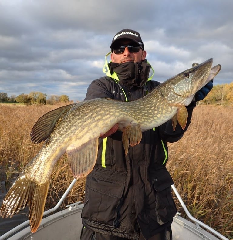 un pêcheur porte un brochet