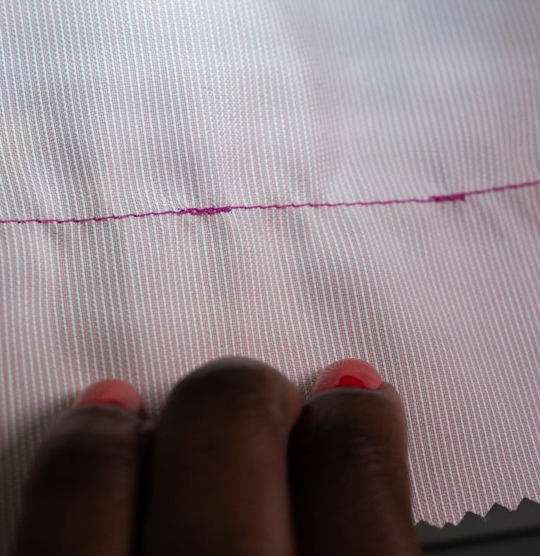Backstitching shown on pink fabric