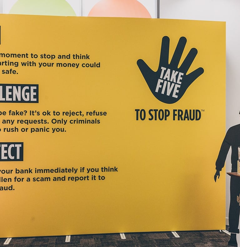 a cardboard thief standing in front of a large banner