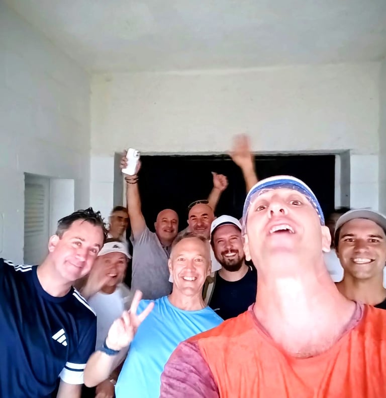 A diverse group of happy male friends taking a cheerful group selfie indoors.
