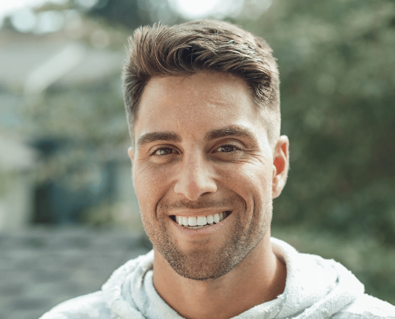 man with thick brown hair smiling
