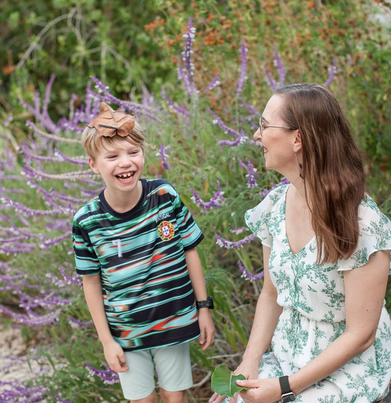 Mother and son enjoy nature together surrounded by purple wildflowers in Lido , Madeira, natural family lifestyle mood