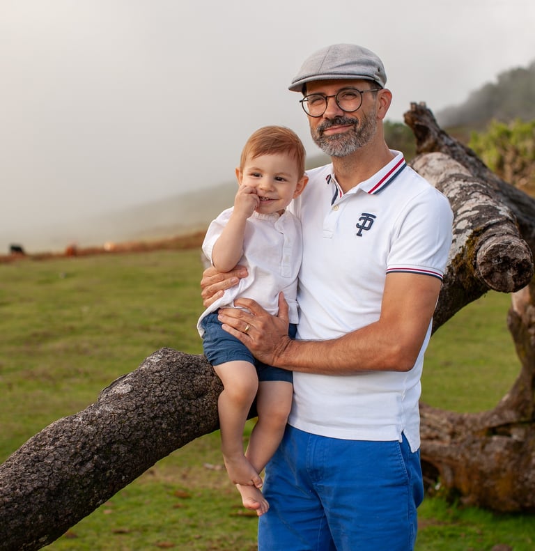Parents smiling at toddler son during golden hour family portrait session at Fanal Forest Madeira