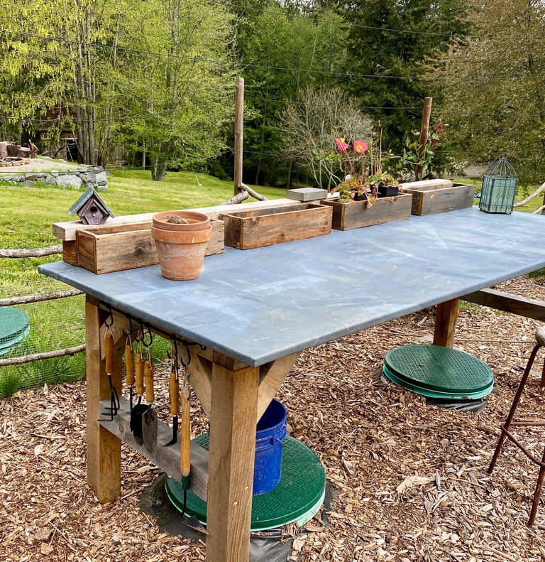 a garden table with pots and tools on it