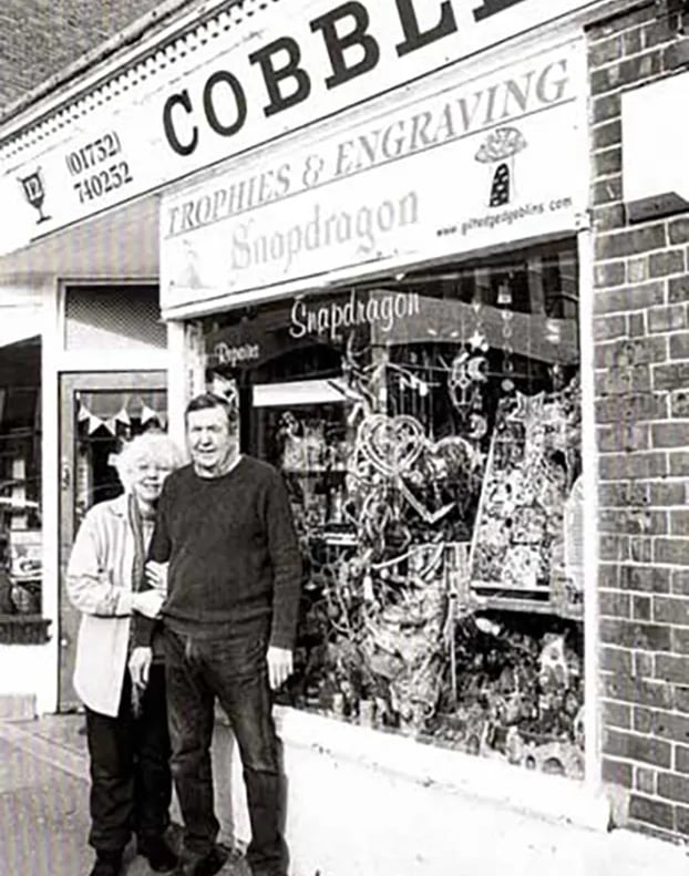 a man and woman standing in front of a store