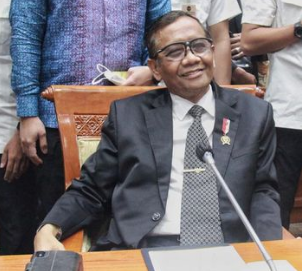 a man in a suit and tie smiling at the camera