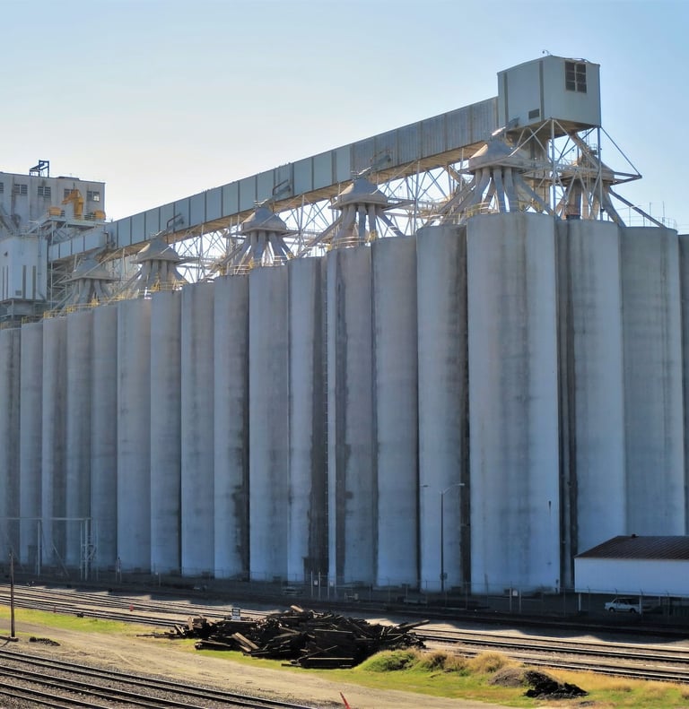 a large grain silo with a train passing by