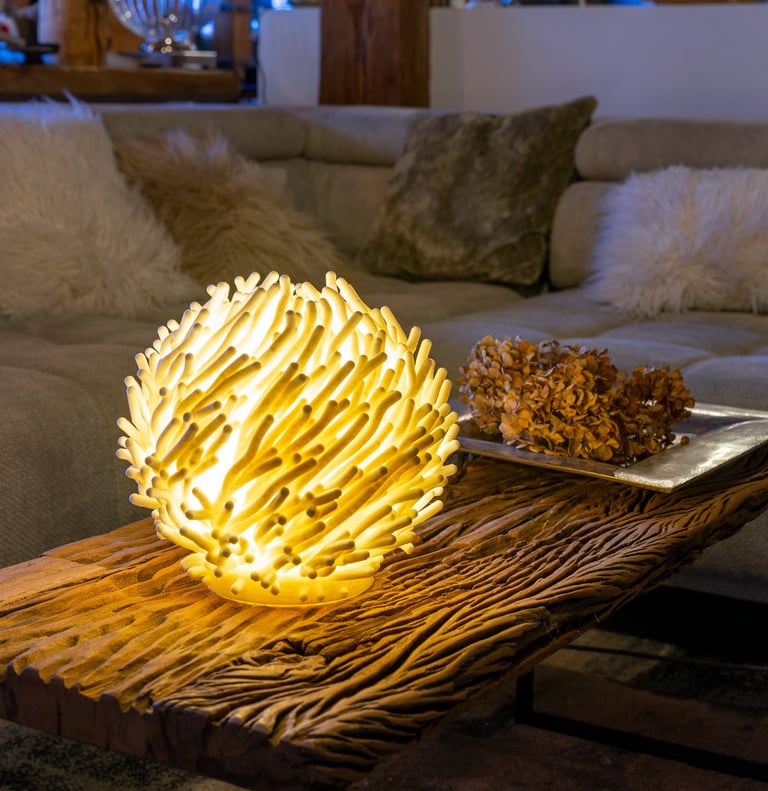 A glowing coral-shaped table lamp sits on a rustic wood coffee table in a cozy living room.