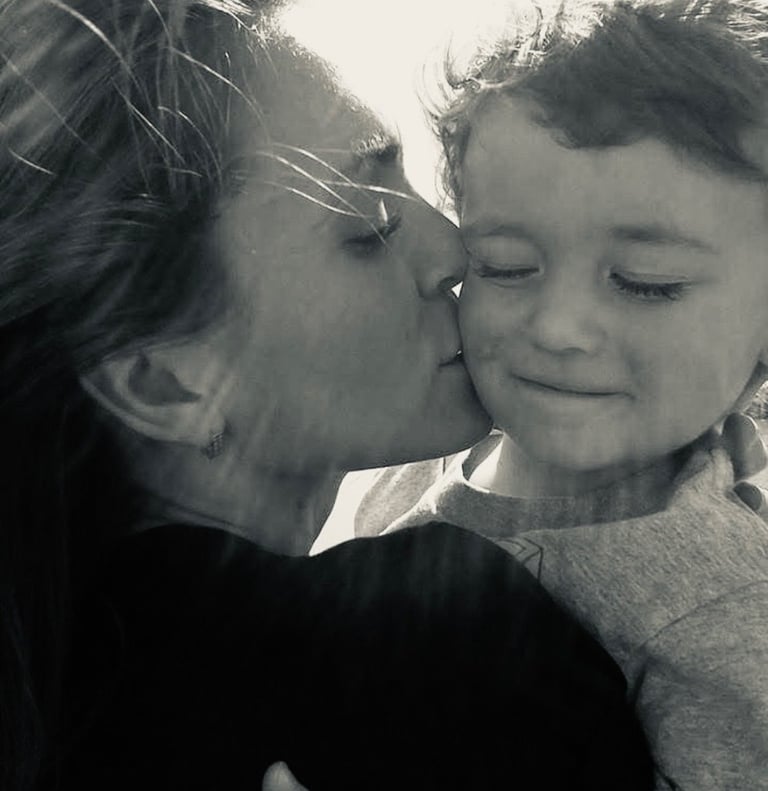 Black and white portrait of a mother kissing her toddler son on the cheek at Seventh Sky VA