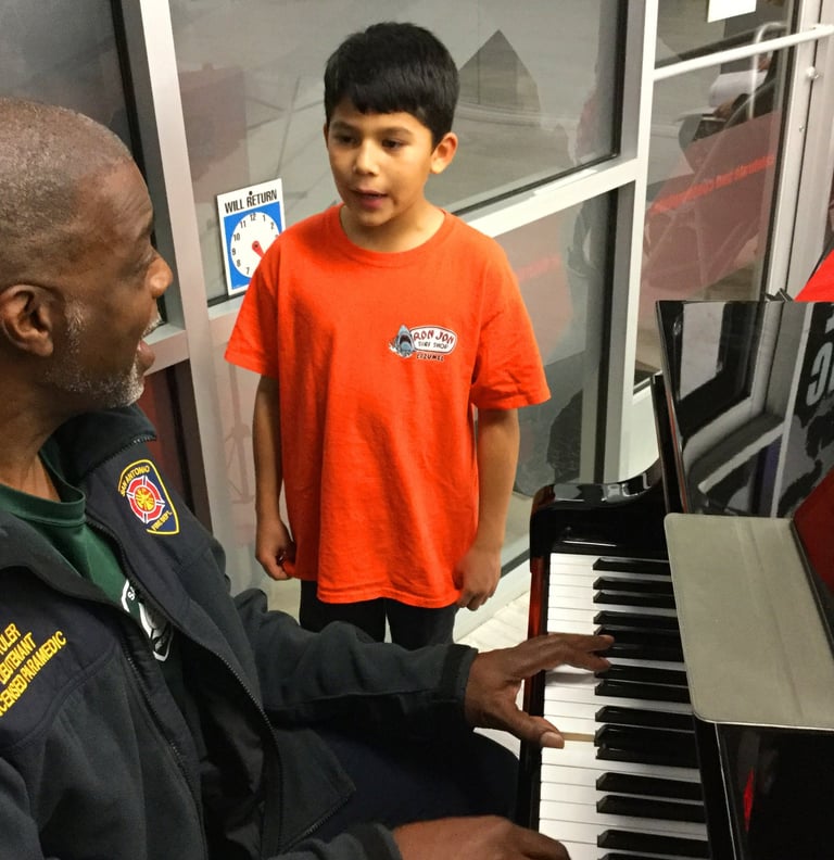 a man playing piano with a young boy singing