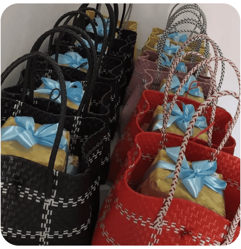 Custom handmade woven plastic bags in black and red prepared for event souvenir distribution.