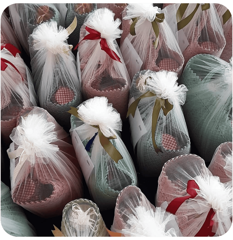 Elegant woven plastic souvenir bags wrapped in tulle fabric for premium gift presentation.