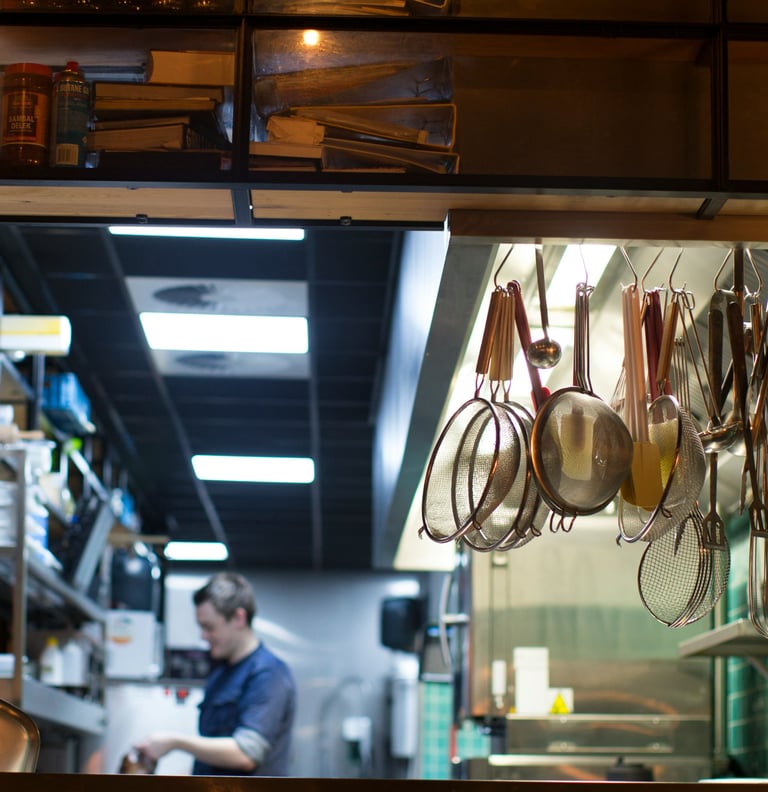 A busy restaurant owner in the kitchen who doesn't have time to keep up with everything.