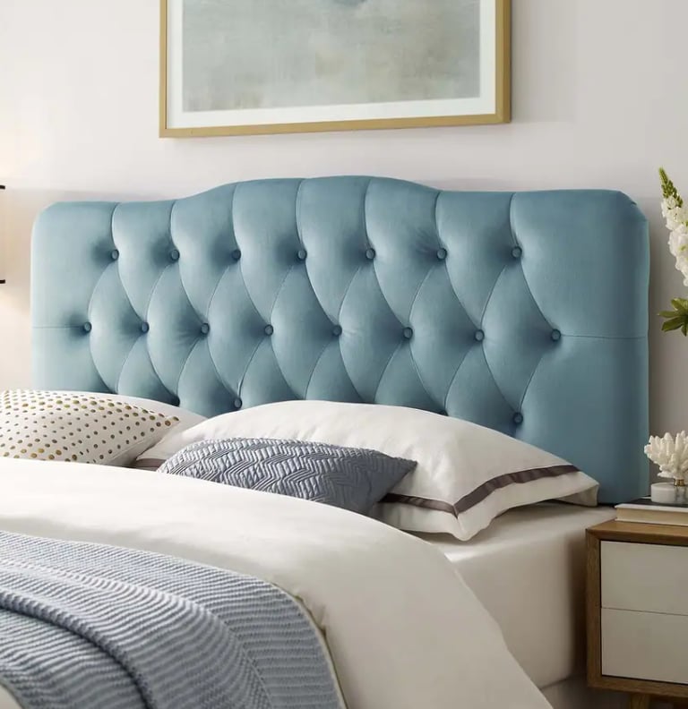Tufted light blue velvet headboard with diamond stitching on a modern bed.