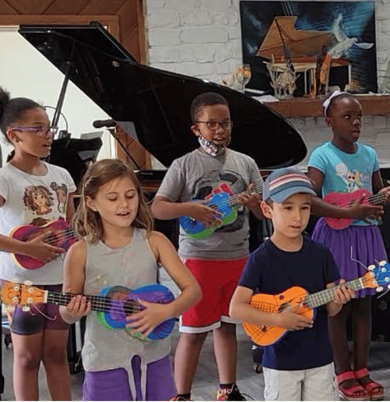a group of children playing ukulele and singing