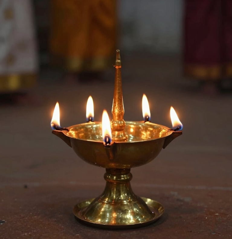 A traditional brass oil lamp with five glowing flames, casting a warm amber light in a dimly lit spiritual space, South Asian / Tamil Nadu, India.